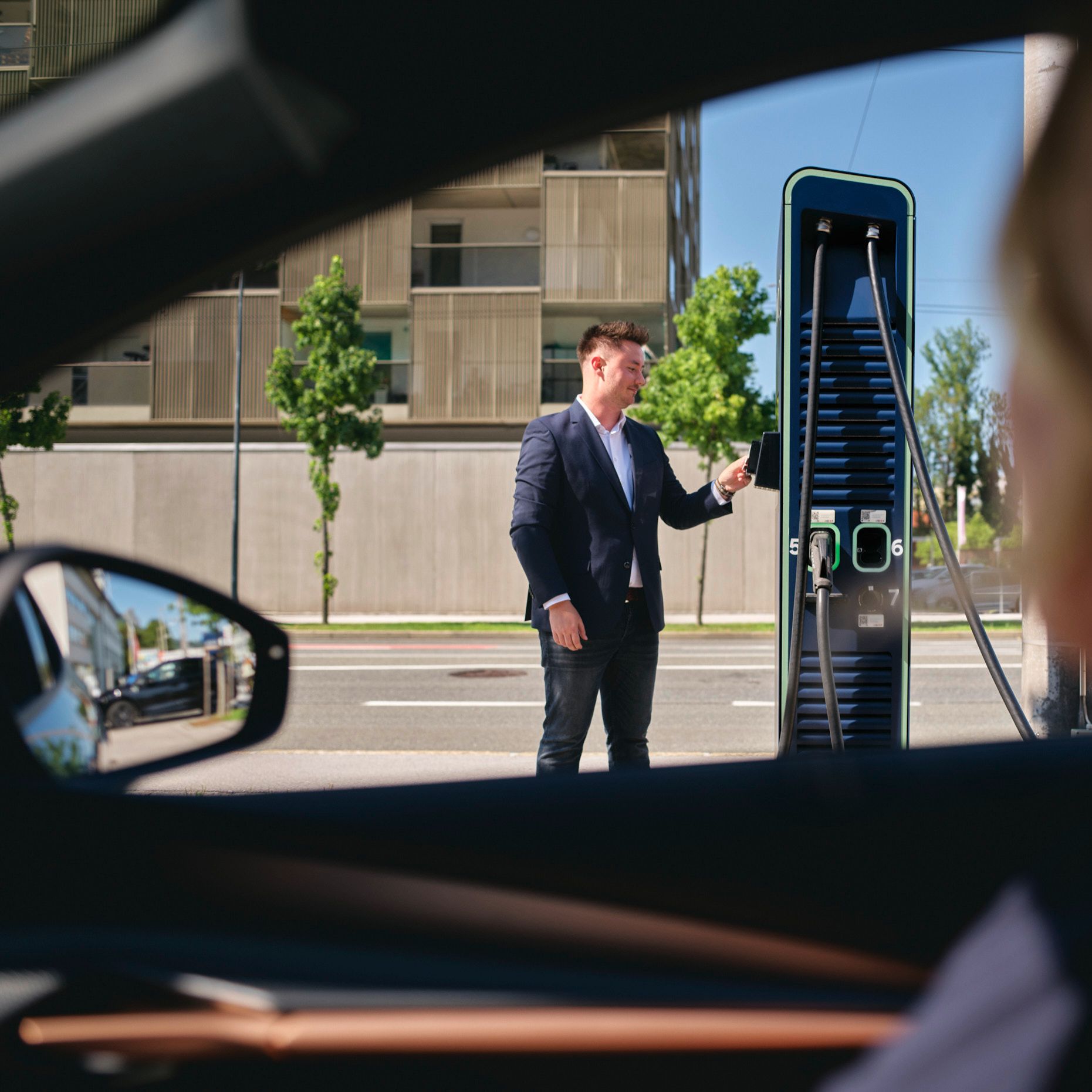 Мъж, стоящ пред зарядна станция с карта