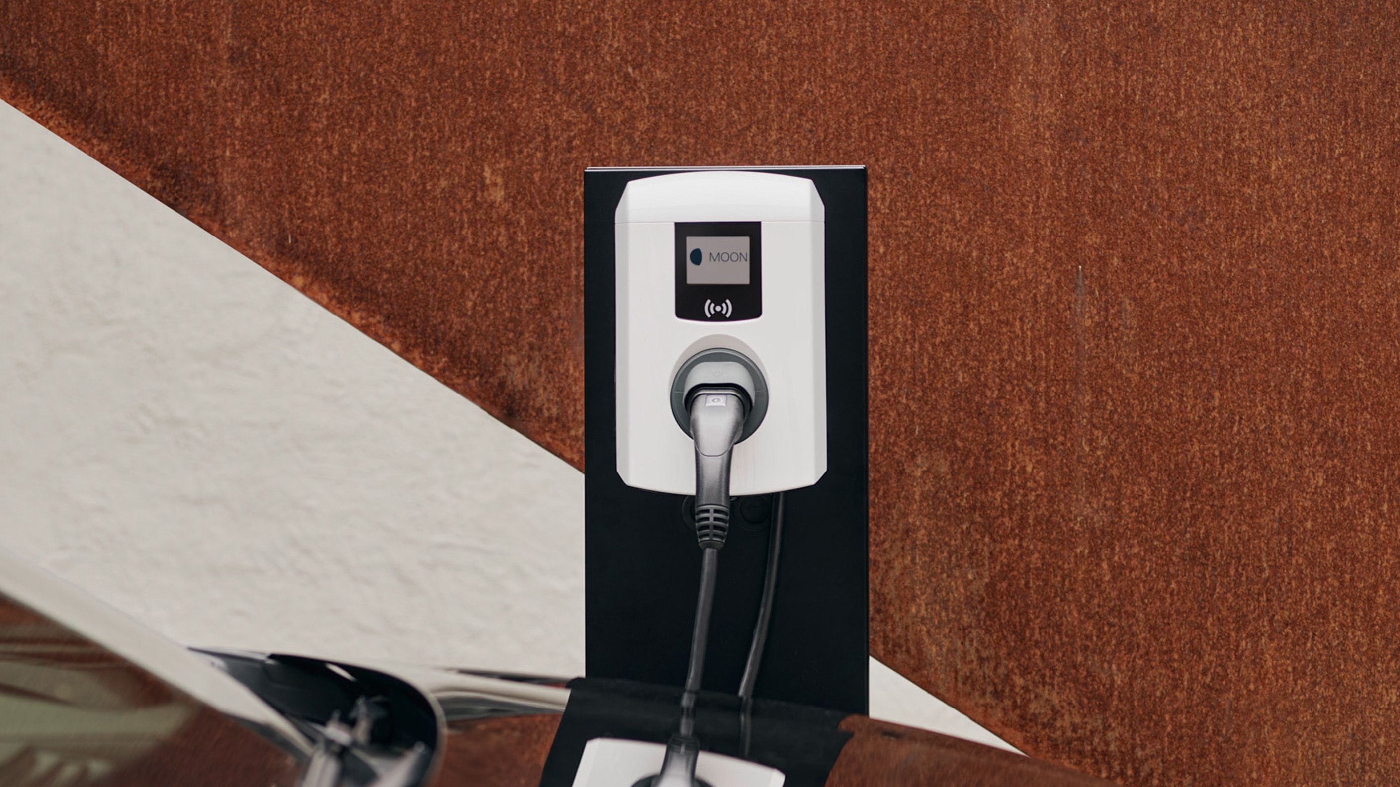 Стенна зарядна станциия зад автомобил