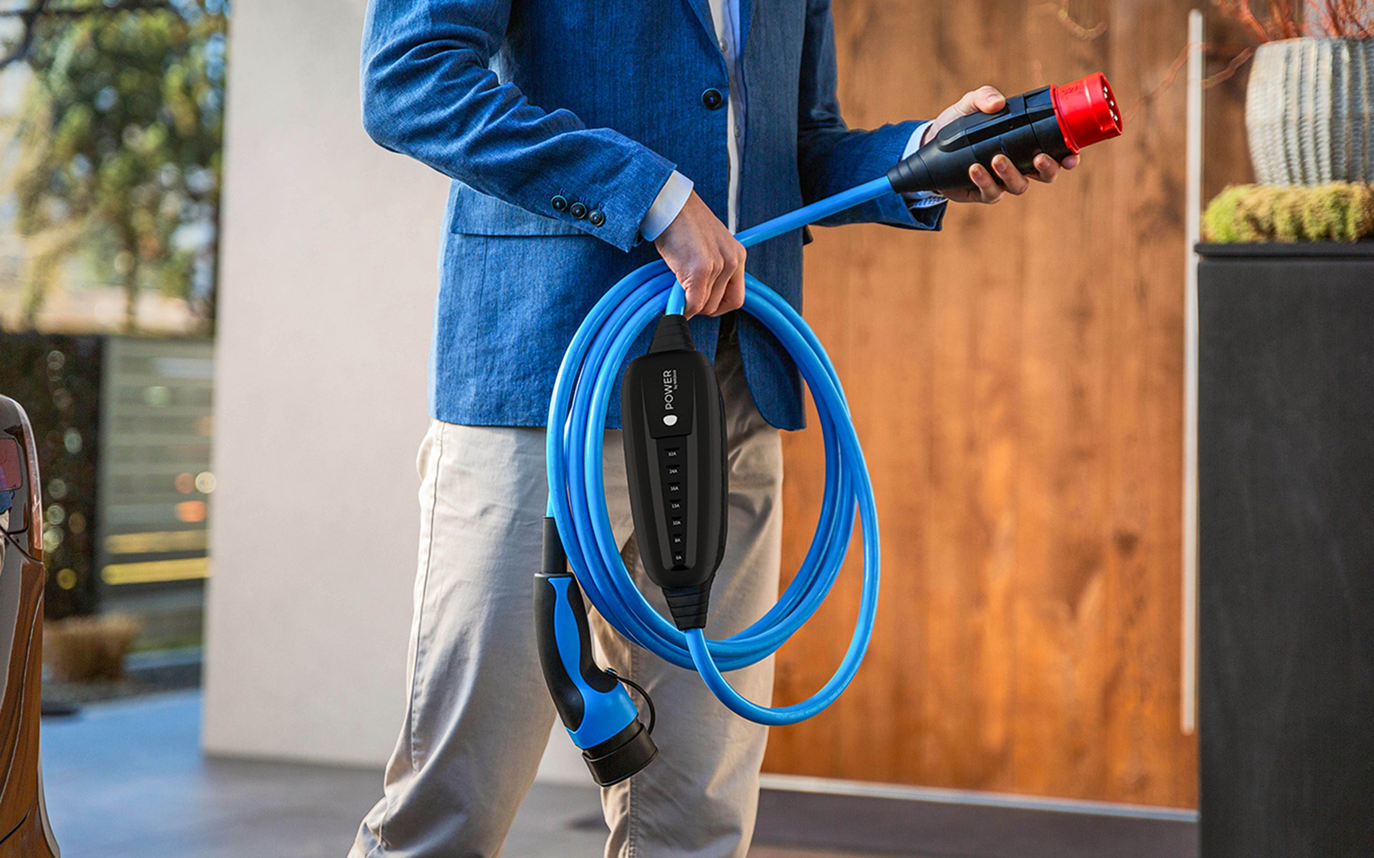 Мъж държи щепсела на кабел в ръката си