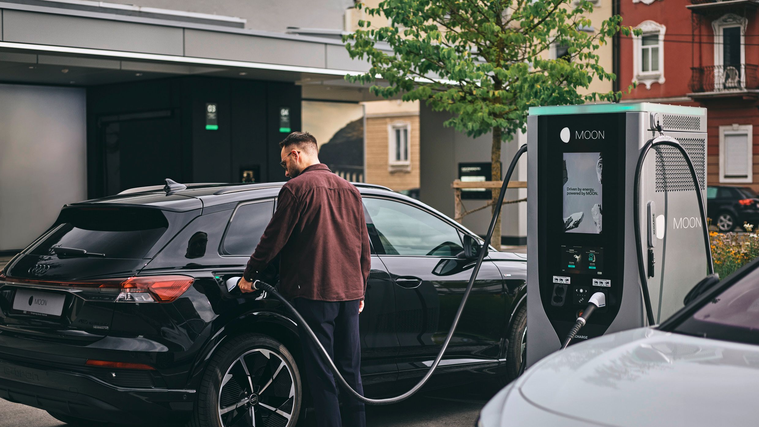 Човек зарежда автомобил на зарядна станция