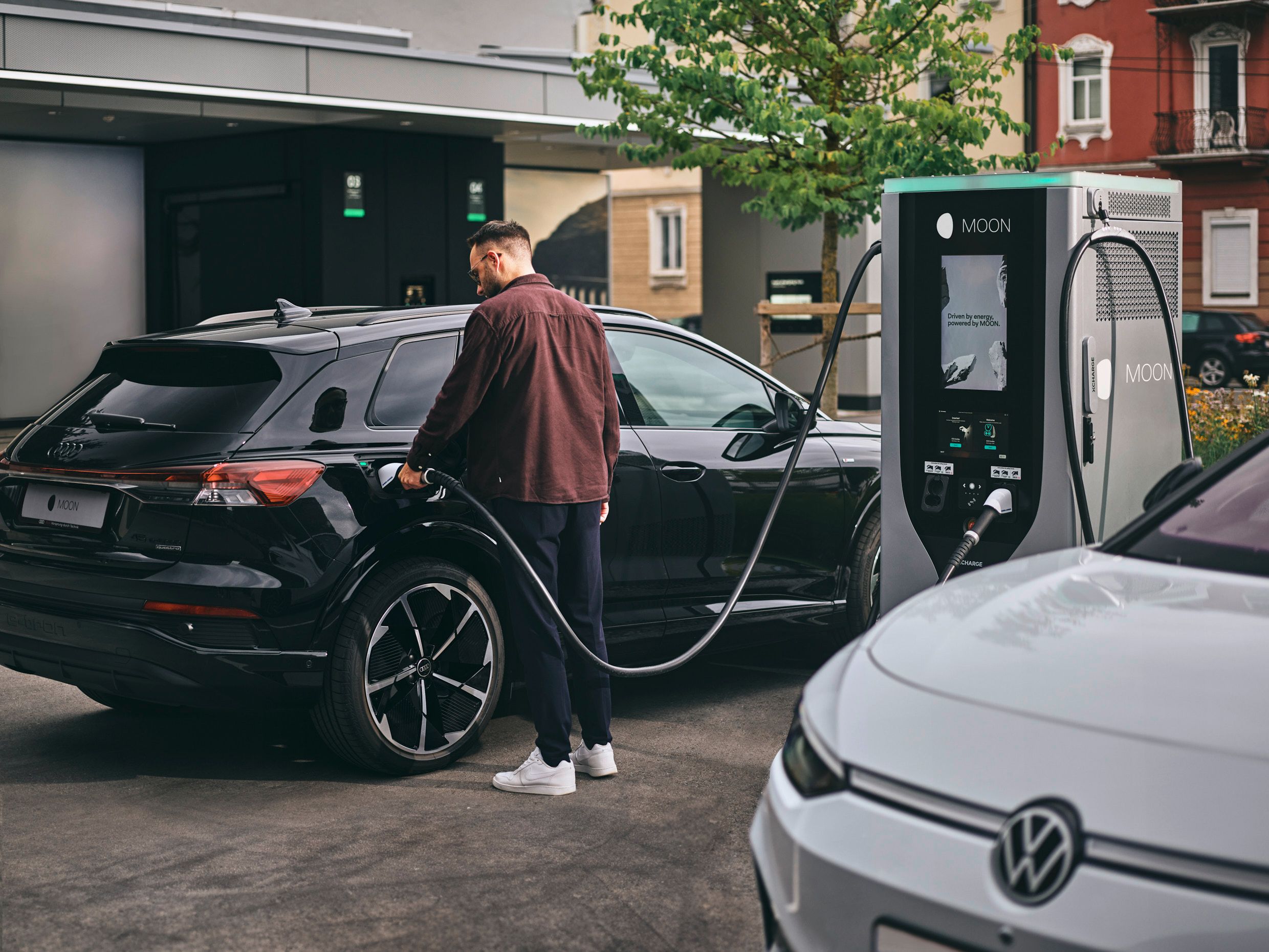 Човек зарежда автомобил на зарядна станция