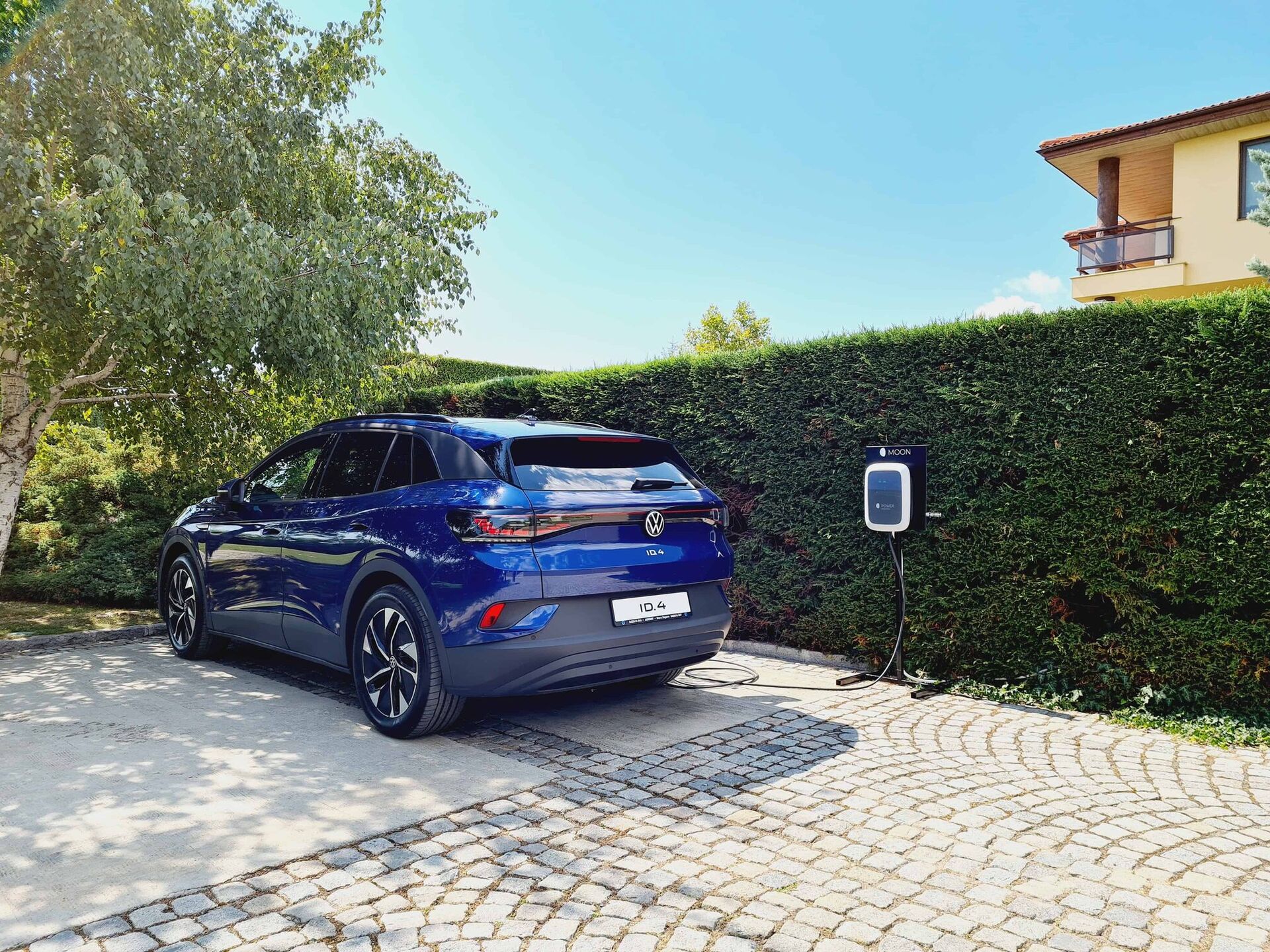 Паркиран син електрически автомобил VW ID. на двор до зарядна станция